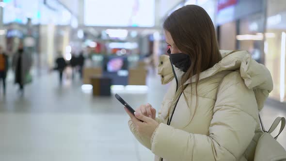 Young Woman in Shopping Mall or Trade Center Using Smartphone Mobile Phone