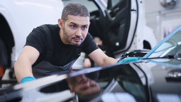 A Man Rubs the Surface of the Car After Polishing alt