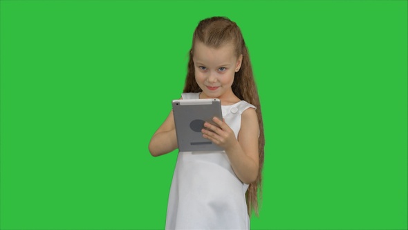 Small girl using tablet computer on a Green Screen, Chroma Key