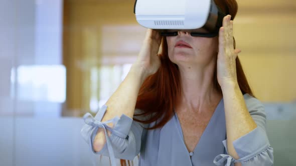 Businesswoman using virtual reality headset in a modern office 4k alt