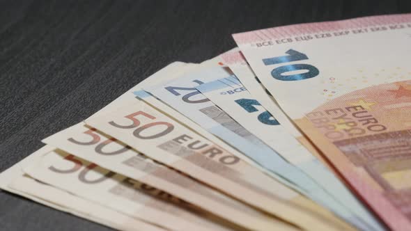 Mixed wad of  Euro money banknotes on table drop on table 4K 3840X2160 UHD video - European Union pa alt