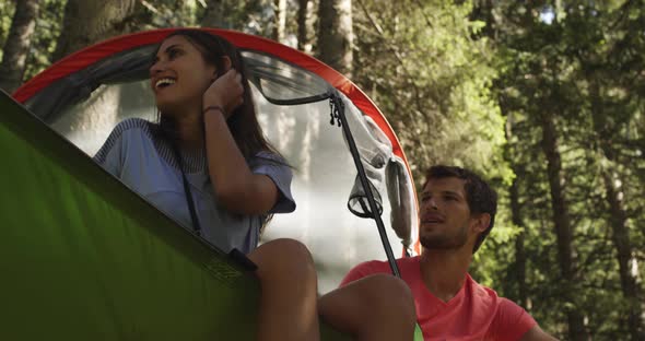 Two Smiling Man and Woman on Hanging Tent Camping in Sunny Forest
