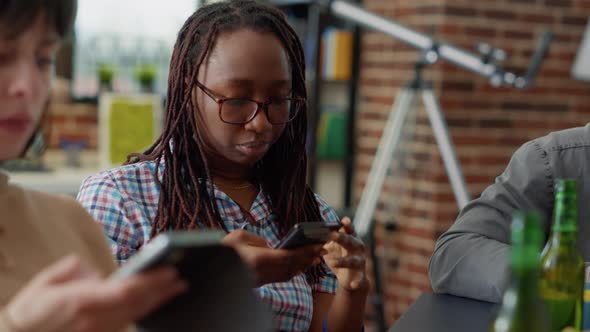 Multiethnic Group of Friends Sitting Together and Using Smartphone alt