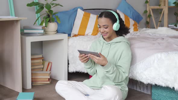 Happy African Teen Girl Talking Video Calling on Digital Tablet at Home