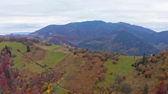 Flu Over Landscapes of Green Hills Under a Layer of White and Fluffy Clouds alt