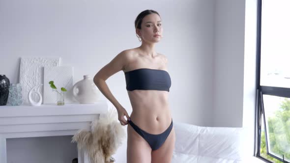 A Charming Model Making A Graceful Stance While Wearing A Black Tube Swimwear. Medium- Full Shot alt