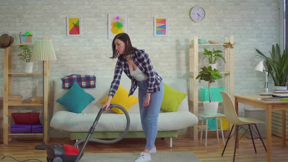 Young Womanat Home Vacuuming the Carpet and Starts Sneezingthe Concept of Allergy To Dust alt