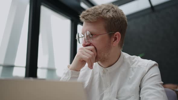 Frustrated Businessman or Trader is Sitting Alone in Office in Front of Laptop and Thinking Hard alt