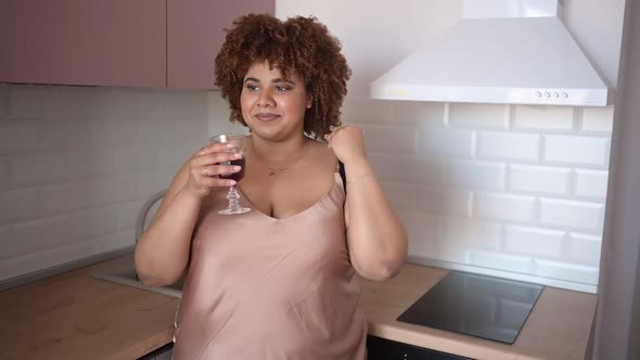 Beautiful Curvy Plus Size African Black Woman Afro Hair Drinking Red Wine on Modern Scandinavian