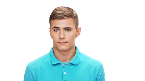Displeased Young Man Looking at Camera Over White Background Slow Motion alt