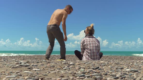 Carefree tourists sit by sea or ocean and look into distance alt