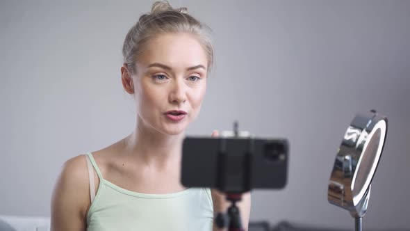 Portrait of Female Beauty Blogger Woman Shows How to Apply Makeup on Face Makes a Stream on Social alt