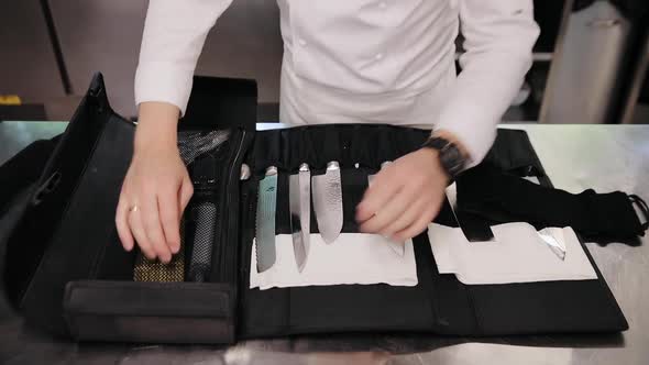 Chef's hands take knife from knives set. Professional Japanese kitchen knives alt