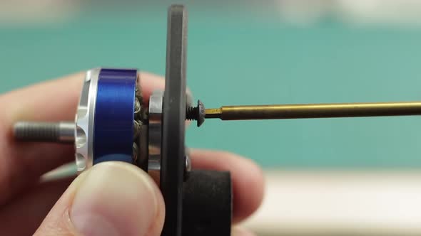 Extreme Close Up of Young Man's Hands Assembling Motor of FPV Racing Drone Using Screwdriver.