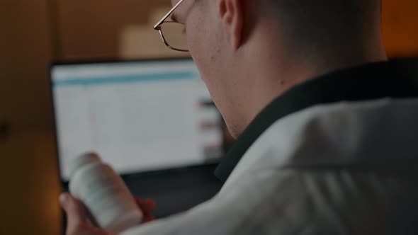Home Consultant Doctor in White Robe Investigates Pills Jar Instruction alt
