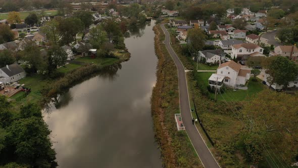 An aerial drone shot over a reflective pond on a cloudy afternoon. The camera dolly in slowly & show alt