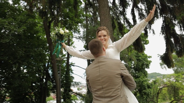 Newlyweds. Caucasian Groom with Bride Dancing in Park. Wedding Couple. Man and Woman in Love alt