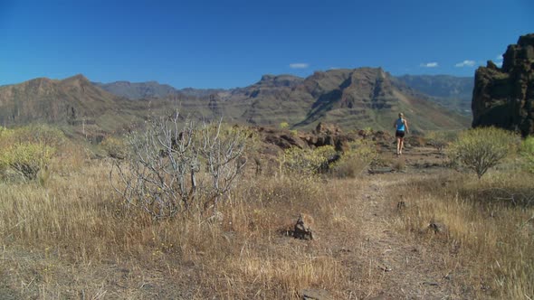 Back View of Woman Running on Dry Grassland - Crane Shot