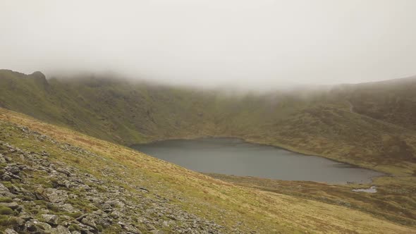 Mountain lake on a valley covered low clouds