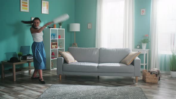 Energetic Woman Has Fun While Cleaning Living Room