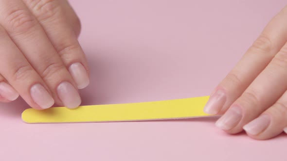 Closeup Woman Hand on Pink Makes Manicure for Herself alt