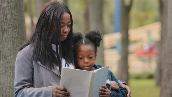 Closeup Young Mom Cute Daughter Sitting in City Park Mother Hugging Little Girl Kid African American alt