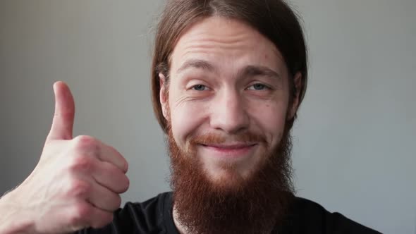 Happy Bearded Man Smiling and Showing Thumb Up Sign Looking at Camera