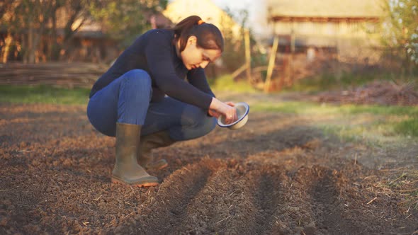 Woman putting seeds in soil