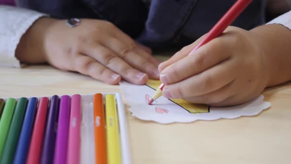 The Child Draws with His Left Hand and a Colored Pencil.