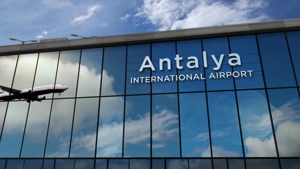 Airplane landing at Antalya Turkey airport mirrored in terminal alt