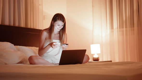 Pretty Caucasian Woman Enjoying Evening Shopping with Credit Card and Modern alt