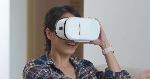Woman watch though virtual reality device at home alt