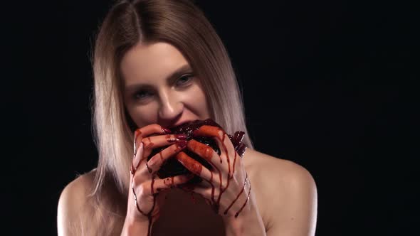 Young Attractive Blonde Woman Eating a Heart Blood Dripping From Her Hands alt