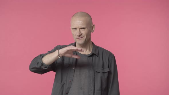 Middleaged Displeased Grimacing Bald Man Squinting and Shaking Head in Disapproval Cover Eyes with alt