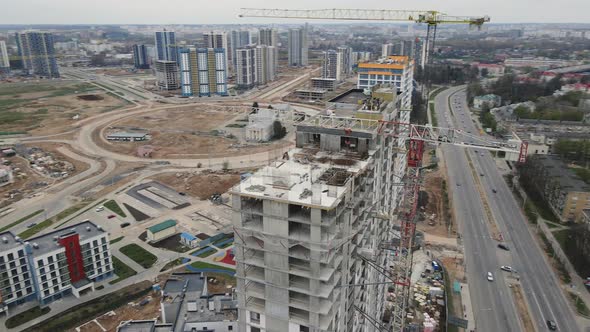 Flight Over The Construction Site. High Rise Buildings Under Construction And Construction Cranes alt