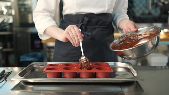 Close-up of chocolate being placed in a baking dish. Brownie preparation. alt