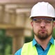 Closeup Portrait of a Young Master Builder in a Protective Hard Hat Looking at the Camera Standing - VideoHive Item for Sale