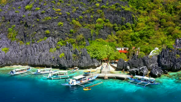 Beautiful Coral Reef, Boats and a Clear Ocean on Matinloc Island, Bacuit Archipelago alt