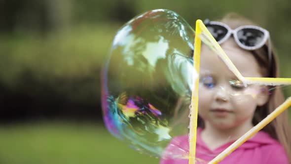 Cute Little Kid Blowing a Bubble in Park