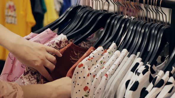 Pretty Business Woman Chooses Clothes in Shop alt