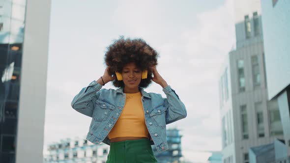 Beautiful young woman with curly hairstyle and fashionable clothes alt