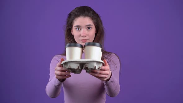 The Charismatic Young Woman Careful with Four Glasses of Coffee in Her Hand Stretches Them Displays alt