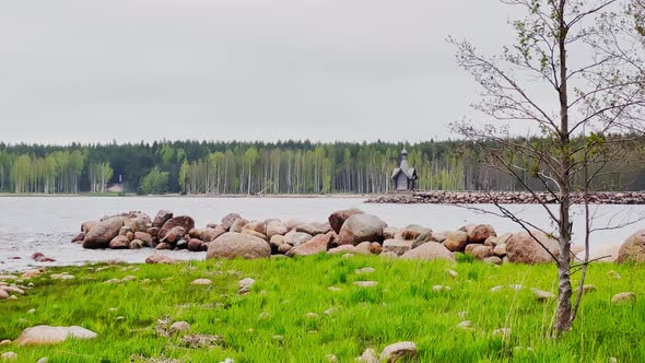 An Old Chapel Stands on a Stone Promontory on the Water in Leningrad Region Russia at Cloudy Weather alt
