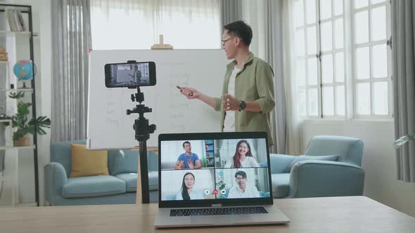 Teacher Shoots Video By Smartphone And Having Video Call On Laptop While Teaching English At Home alt