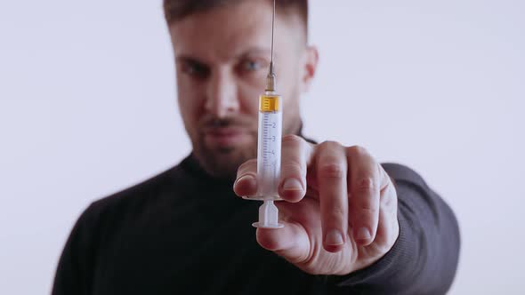 Handsome Man Holding a Syringe