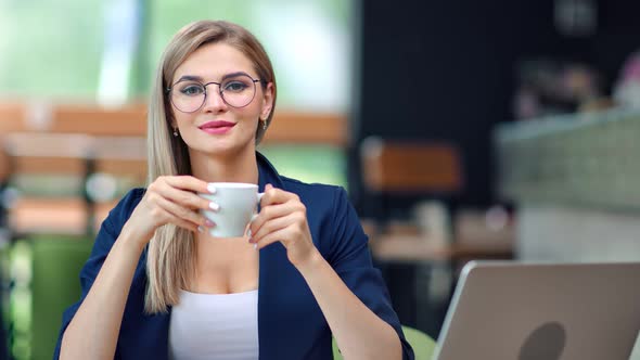 Adorable European Business Female in Glasses Holding Coffee Cup Enjoying Break at Cafe Medium Shot alt