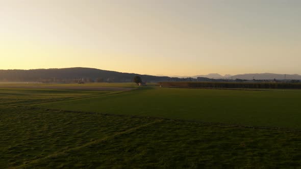 Aerial clip of the Bavarian flat land during sunrise, with a strong sun backlight. alt