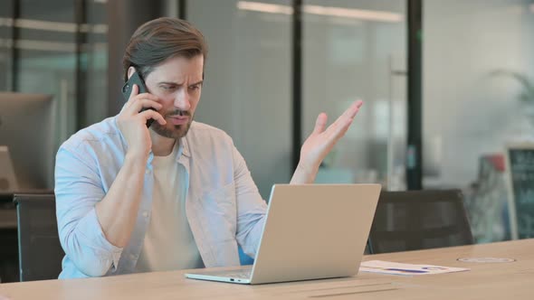 Angry Mature Adult Man with Laptop Talking on Phone alt