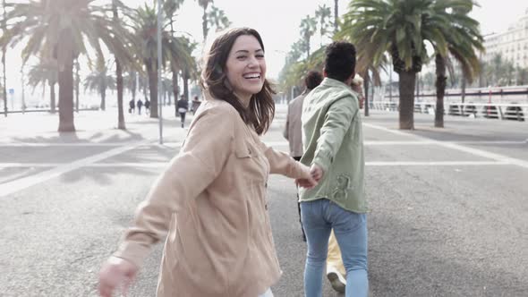 United Young Friends Running Happily Together While Holding Hands Outdoors alt