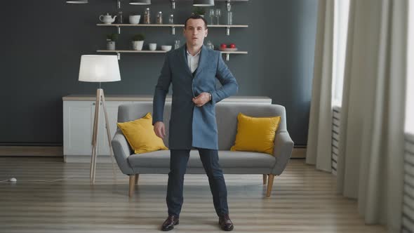 An Attractive Man Thinks To Dress and Try on Different Clothes in a Dressing Room for a Business